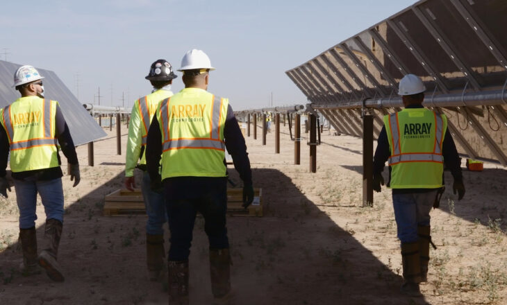 Worker walking in between rows of solar panels