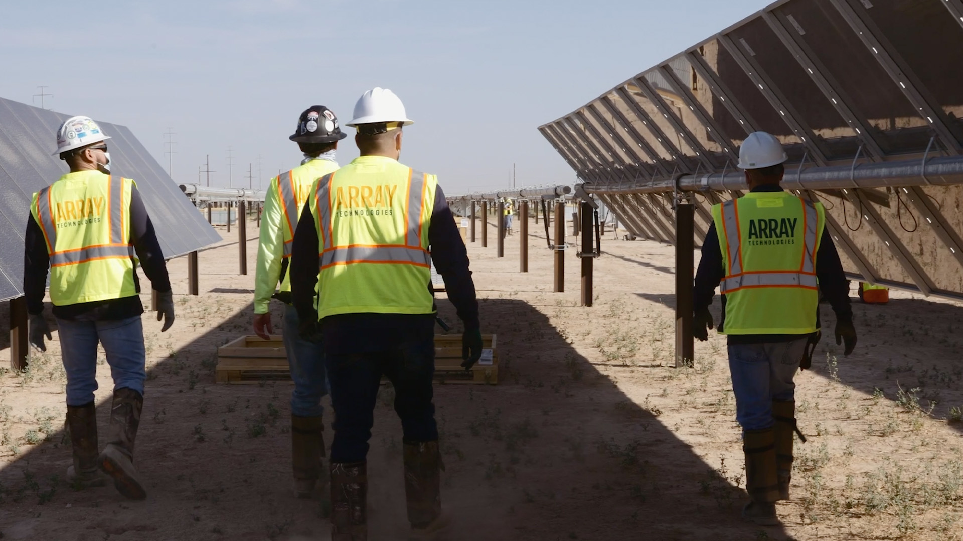 Worker walking in between rows of solar panels